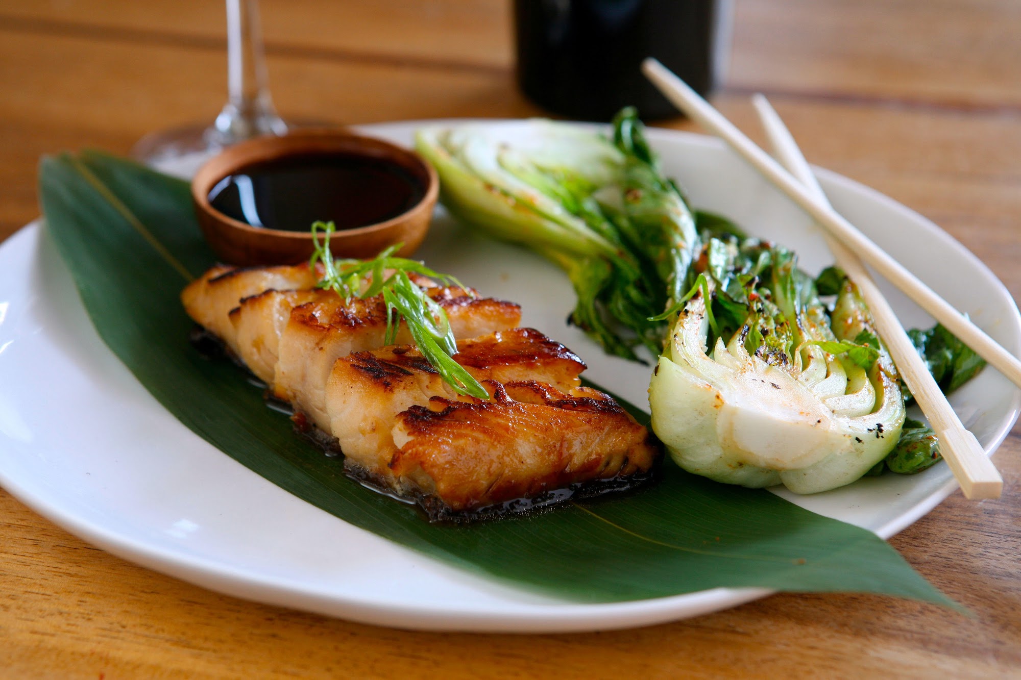 Glazed fish on banana leaf with fresh herbs by Chef Tien Tran